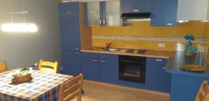 伦山前比绍夫斯海姆Ferienwohnung Gutwin的厨房配有蓝色橱柜和带桌布的桌子