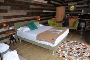 沙布利Lodges des grands crus的卧室配有一张床铺,位于带木墙的房间内