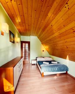 耶维克Żywiecka Przystań的一间卧室设有一张床和木制天花板