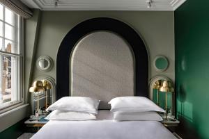 伦敦Henrietta Experimental的一间卧室配有一张床和一面大镜子