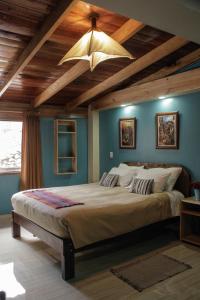 奥兰太坦波Doña Catta Casa Boutique的一间卧室设有一张带木制天花板的大床