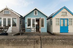 基督城Stargazing Beach Hut on Mudeford Sandbank with wake up sea views的码头上的两座蓝白房子