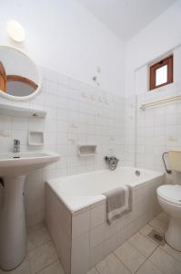 圣加利尼阿多尼斯酒店的带浴缸、盥洗盆和卫生间的浴室
