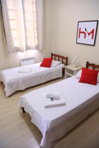 南卡希亚斯Hotel Murialdo的客房内的两张床和红色枕头
