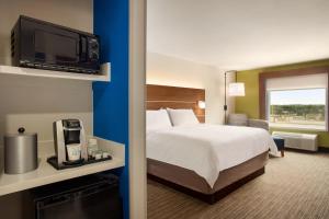 瑟西Holiday Inn Express & Suites Searcy, an IHG Hotel的酒店客房,配有床和电视