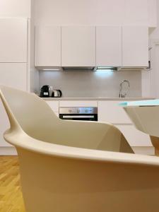 佩鲁贾STAY home experience的厨房配有白色橱柜和白色椅子