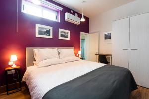佩奥拉Monreal Boutique Townhouse - R024RM6的卧室配有白色的床和紫色墙壁