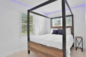维洛海滩Kaslo Breeze的卧室配有华盖床、白色墙壁和窗户。