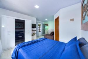 邦比尼亚斯Recanto da Conceição的一间带蓝色床的卧室和一间客厅