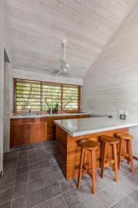 罗阿坦Barefoot Cay Resort的大厨房设有大柜台和两张凳子