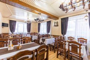 亚西尼亚У Румуна的餐厅设有桌椅和窗户。