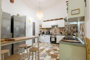 马德里Social - Coliving & Coworking - Madrid的厨房配有白色橱柜和酒吧凳子