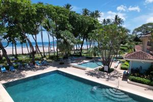 塔马林多Hotel Tamarindo Diria Beach Resort的享有游泳池和海滩的空中景致