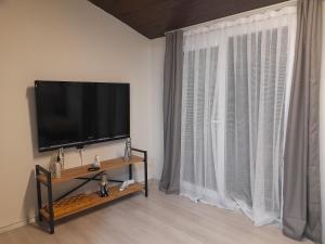 KonakLuxury Duplex in the Center of Alsancak的客厅配有平面电视和窗户。