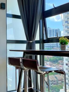 吉隆坡Private Jacuzzi Staycation at KL City 152的窗前的一张桌子和两把椅子