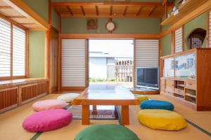 富士吉田市古民家再生ホテル　Relink的客厅配有桌子和五颜六色的椅子