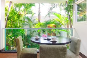 攀瓦海滩达维娜海滩酒店的配有大窗户的客房内的桌椅