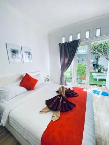 珀尼达岛Umah Putih的一间卧室配有一张带红色毯子的大床