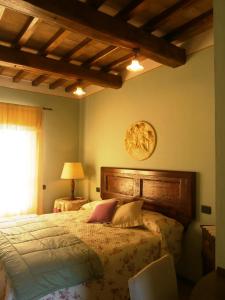 蒙特法尔科Tenuta Colverano的一间卧室配有一张带木制床头板的床和窗户。