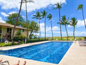 基黑Waiohuli Beach Hale D227 - Aloha La'i - Oceanfront/1b1b/Wifi/AC/Cable/Pool/Extras的一座棕榈树游泳池和一座房子