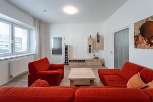 布尔诺附近斯拉夫科夫Apartment Yogiam的客厅配有两张红色的沙发和一张桌子