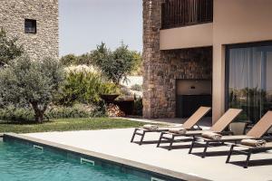 普利莫顿Villas Misto的一座房子旁的游泳池,配有两把躺椅