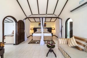 蒙巴萨PrideInn Flamingo Beach Resort & Spa Mombasa的一间卧室配有一张床和一张沙发