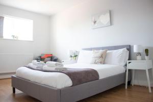 拉夫堡Large 1st Floor Open Plan Apartment的一间卧室配有带白色床单和枕头的床。