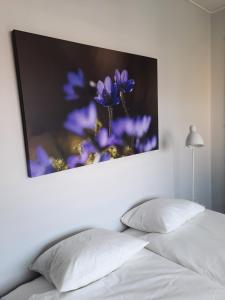 利雪平Broholm Bed&Breakfast的紫色花的照片在床上方