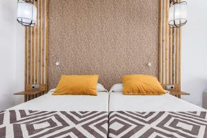 科蒂略Cotillo Sunset的床上有两个橙色枕头