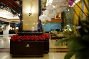 曼谷Town in Town Hotel Bangkok - SHA Plus的大堂设有红色鲜花,酒店还设有餐厅