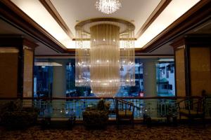 曼谷Town in Town Hotel Bangkok - SHA Plus的酒店大堂的大吊灯,配有椅子