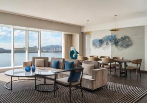 厦门厦门集美海景皇冠假日酒店（免费Mini Bar）的客厅配有沙发、椅子和桌子