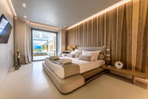 纳克索乔拉Avgoustos Suites Naxos的一间卧室设有一张大床和一个大窗户