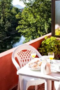 坎加斯-德奥尼斯Alojamiento Covadonga的阳台上的白色桌子和两杯葡萄酒