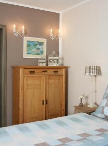 科赫姆魏恩堡菲伦豪斯旅馆的一间卧室配有木制橱柜和一张床