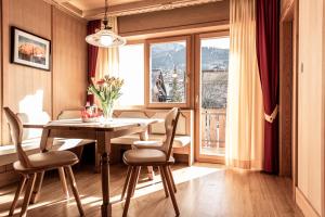 卡斯特尔罗托卡斯特勒塞尔森阿姆公寓式酒店的一间带桌椅和窗户的用餐室