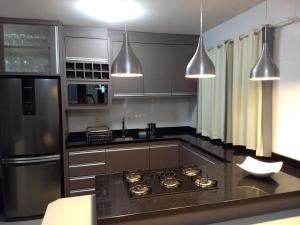 弗洛里亚诺波利斯Beach House Nascer do Sol的厨房配有炉灶和冰箱。