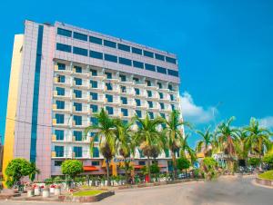杜阿拉FAYA Hotel的一座棕榈树环绕的大建筑