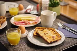 根特根特展会假日酒店的一张桌子,上面放有烤面包片、鸡蛋和橙汁