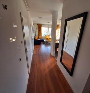 萨格勒布Apartman EVA ZAGREB的一个带镜子的走廊和一间客厅