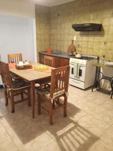 洛博斯El Descanso的厨房配有木桌、椅子和炉灶。