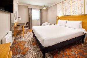 伯明翰伯明翰中心宜必思尚品酒店的酒店客房设有一张大床和一张书桌。