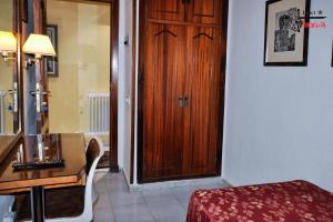 萨拉曼卡阿拉贡酒店的客房设有木门、桌子和书桌。