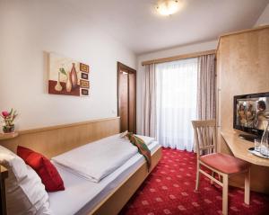 弗拉绍Pension Haus am Dorfplatz的配有一张床和一张书桌的酒店客房
