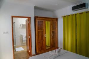 拉迪格岛Villa Charette-Self Catering Villas的一间卧室配有绿帘和镜子