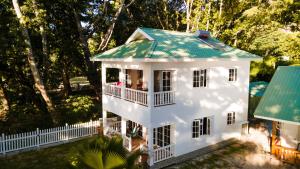 拉迪格岛Villa Charette-Self Catering Villas的享有白色房屋的空中景致,设有绿色屋顶