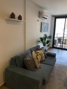 科尔多瓦Departamento Boutique II en Nueva Cordoba的客厅配有带枕头的蓝色沙发