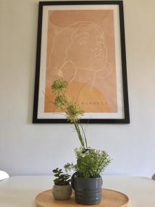 科莫蒂尼Nikoletta's Home 2的一张墙上的画,桌子上有两个植物