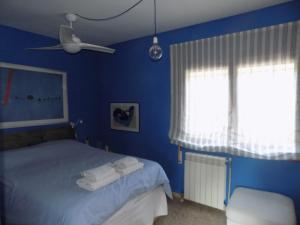 坎佩略Bungalow CASIOPEA Internet 300 Mb SAT SMARTTV的蓝色卧室,配有带毛巾的床